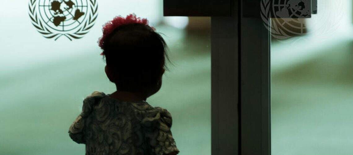 A child stands by the doors to the General Assembly Hall during the high-level meeting of the General Assembly on the occasion of the thirtieth anniversary of the adoption of the Convention on the Rights of the Child.